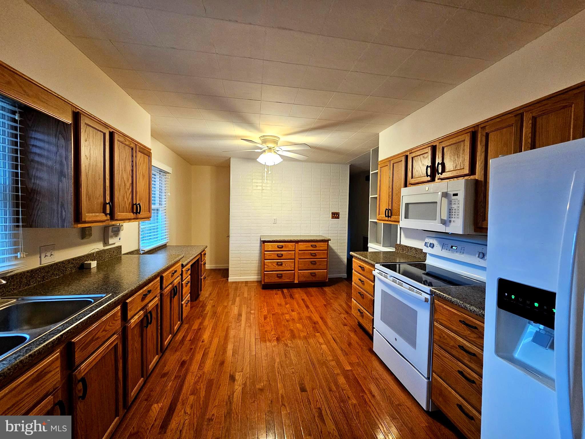310 Bethel Road Paw Paw, WV 25434 - Photo 3 of 30 a kitchen with stainless steel appliances a sink stove and wooden floor