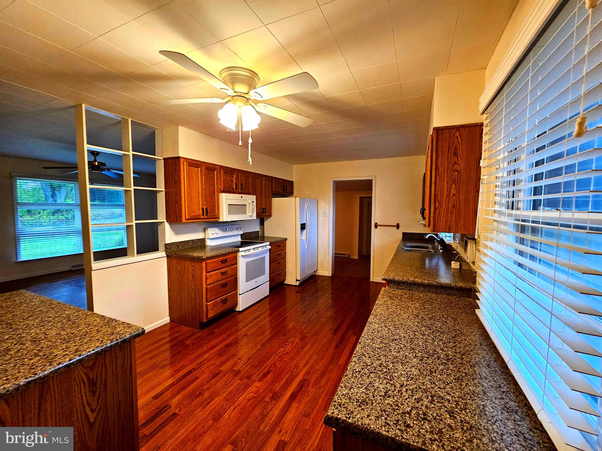 310 Bethel Road Paw Paw, WV 25434 - Photo 4 of 30 a kitchen with stainless steel appliances granite countertop a refrigerator a stove and a wooden floors