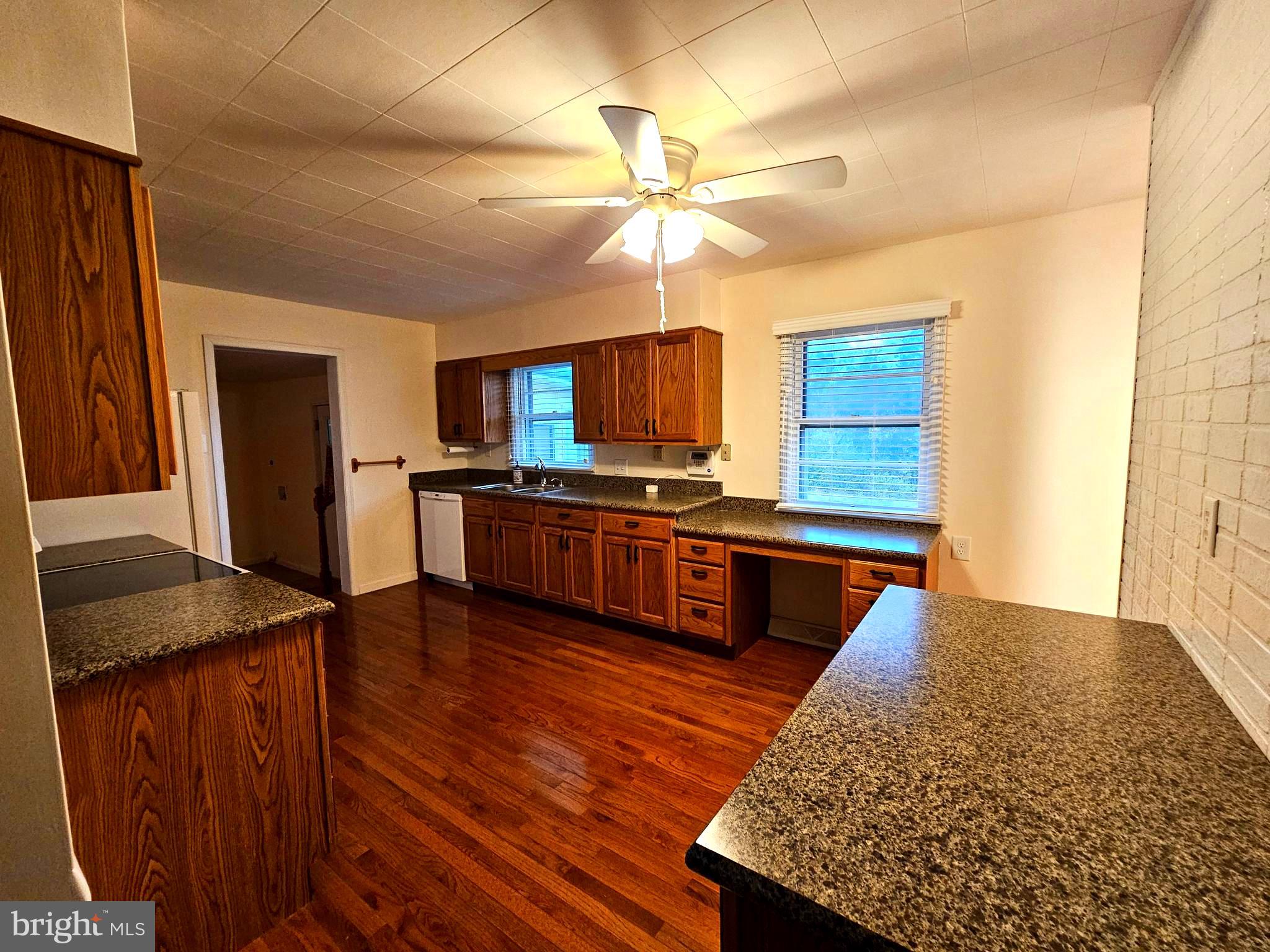 310 Bethel Road Paw Paw, WV 25434 - Photo 5 of 30 a kitchen with stainless steel appliances kitchen island granite countertop wooden cabinets a refrigerator a sink a stove with wooden floor and cabinets