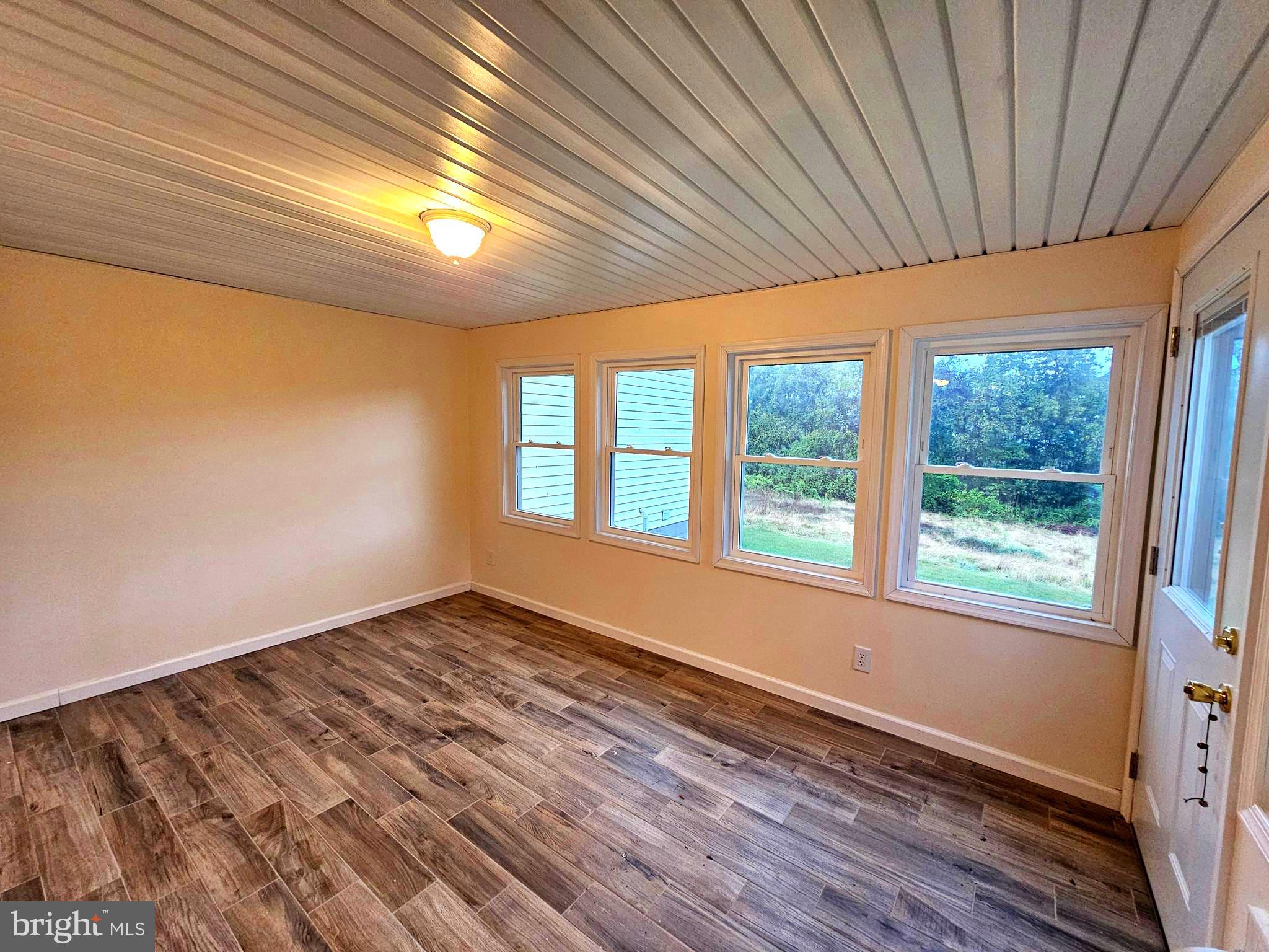 310 Bethel Road Paw Paw, WV 25434 - Photo 10 of 30 a view of an empty room with wooden floor and a window