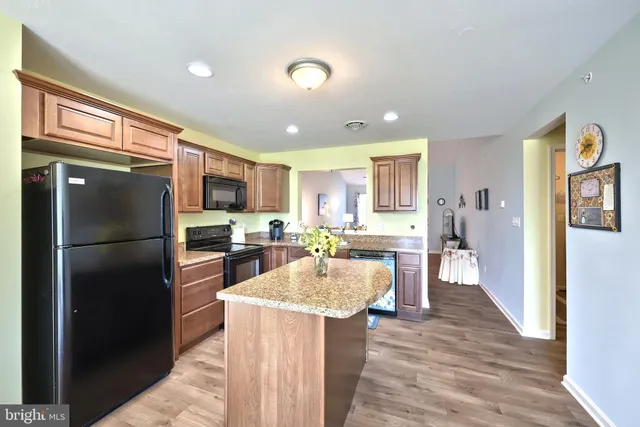 a kitchen with a refrigerator a kitchen island a stove a refrigerator cabinets and living room