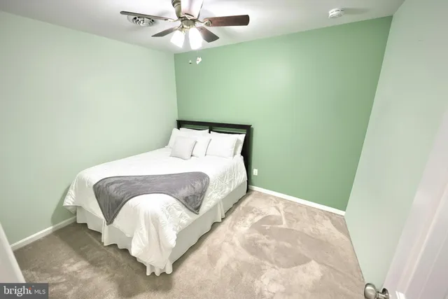 a bedroom with a bed and a fan