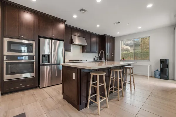 a kitchen with stainless steel appliances granite countertop a refrigerator and a stove top oven