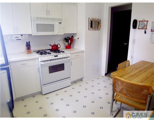 66 East Cliff Road Colonia, NJ 07067 - Photo 8 of 18 a kitchen with a stove and white cabinets