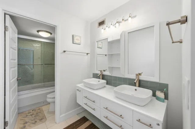 a bathroom with a sink double vanity granite tub and shower