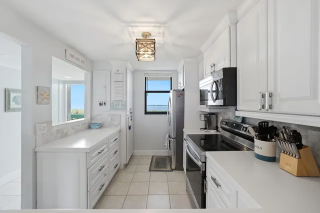a kitchen with granite countertop a sink stove and cabinets