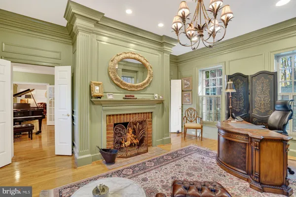 a living room with furniture a fireplace and a chandelier