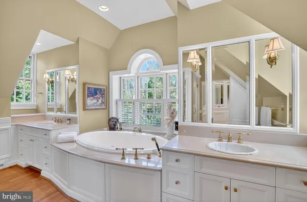 a bathroom with a granite countertop sink mirror and a bathtub
