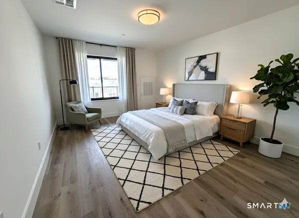 a bedroom with a bed and a potted plant