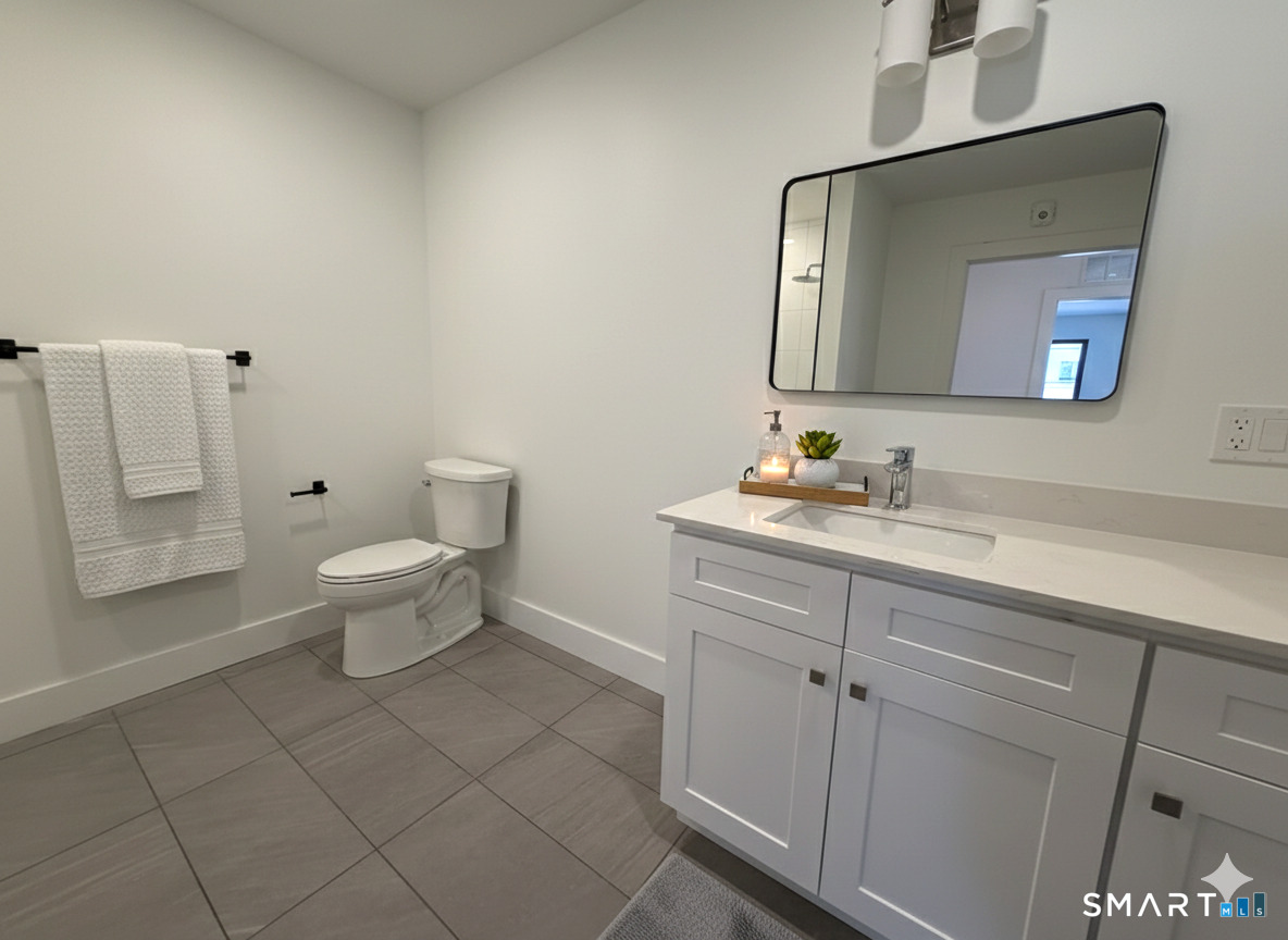 414 Mather Street, Unit 2D Hamden, CT 06514 - Photo 5 of 6 a bathroom with a toilet sink and mirror