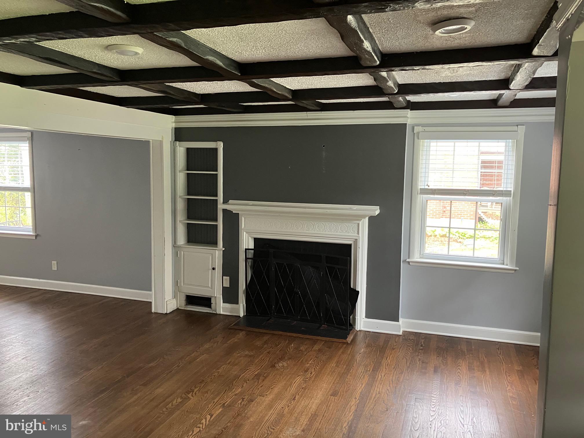 4008 Deepwood Road Baltimore, MD 21218 - Photo 3 of 18 a view of an empty room with wooden floor fireplace and a window