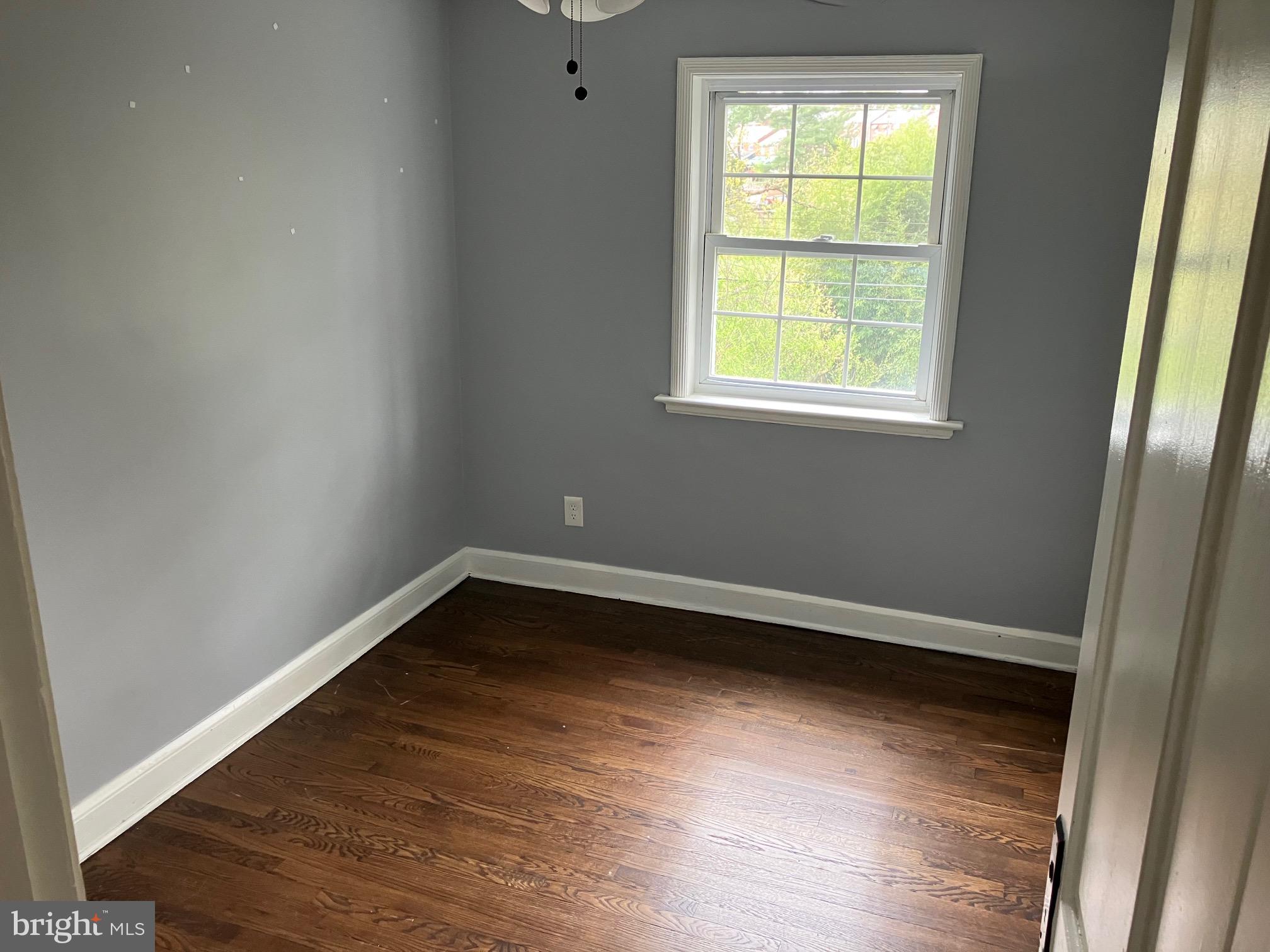 4008 Deepwood Road Baltimore, MD 21218 - Photo 8 of 18 a view of an empty room with wooden floor and a window