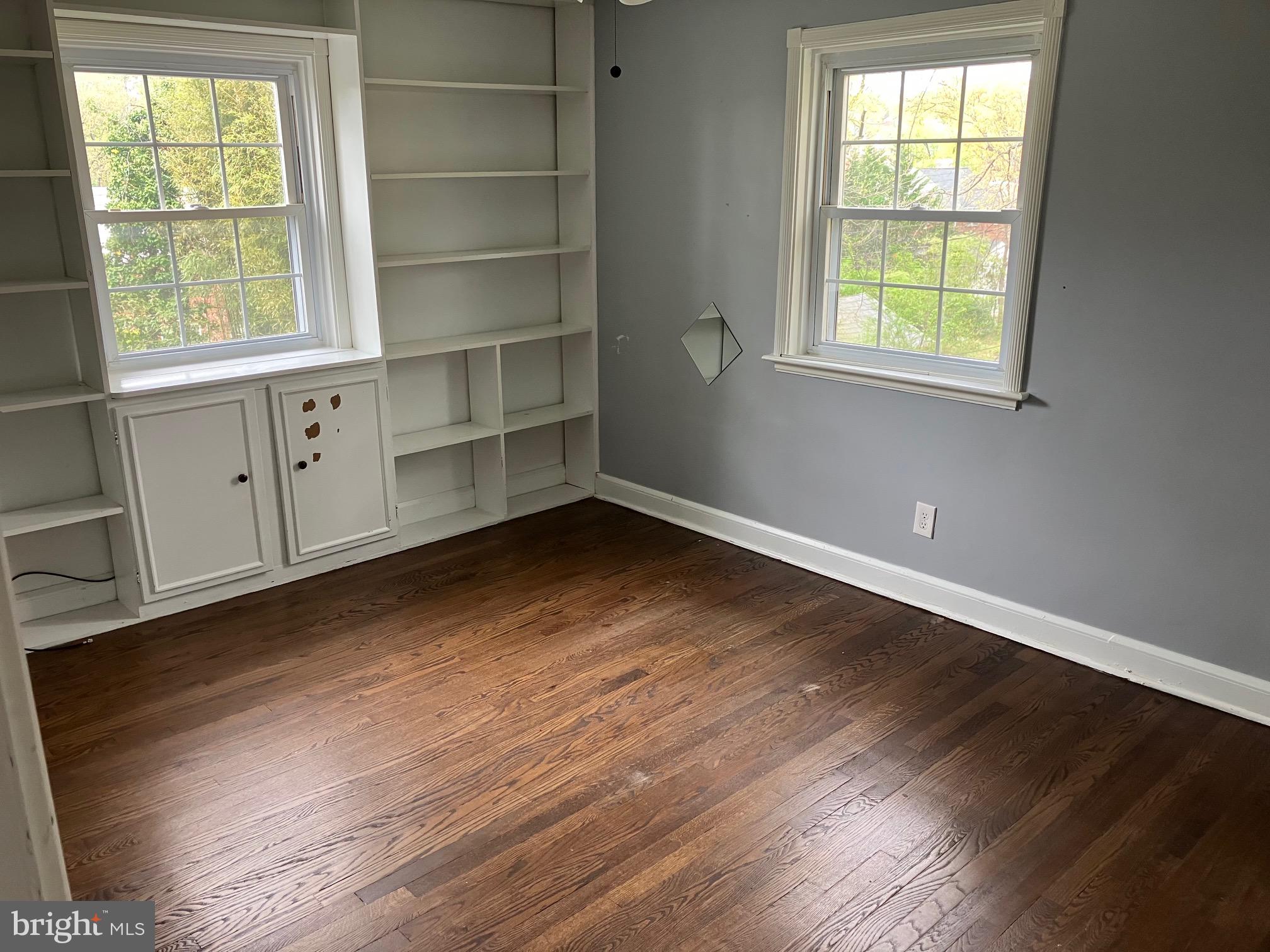 4008 Deepwood Road Baltimore, MD 21218 - Photo 9 of 18 an empty room with wooden floor and windows