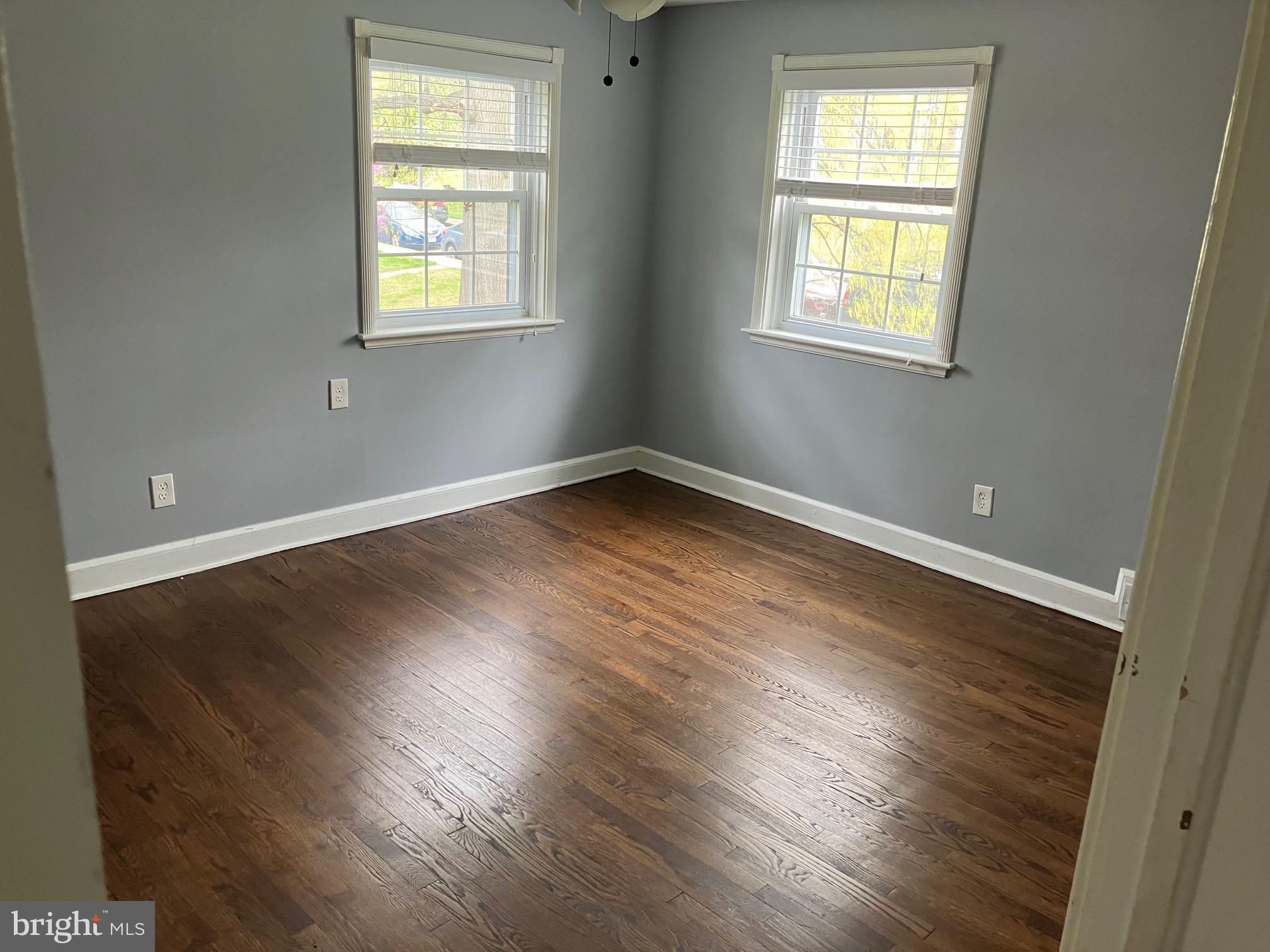 4008 Deepwood Road Baltimore, MD 21218 - Photo 10 of 18 an empty room with wooden floor and windows
