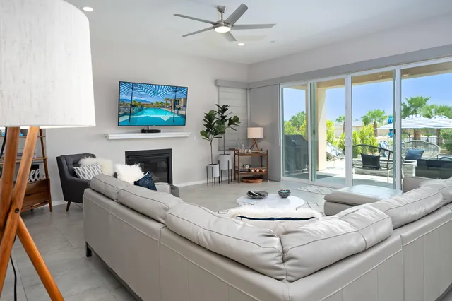 a living room with furniture a flat screen tv and a fireplace