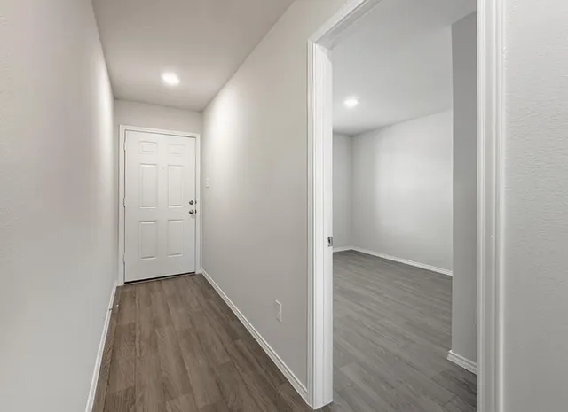 an empty room with a window and wooden floor