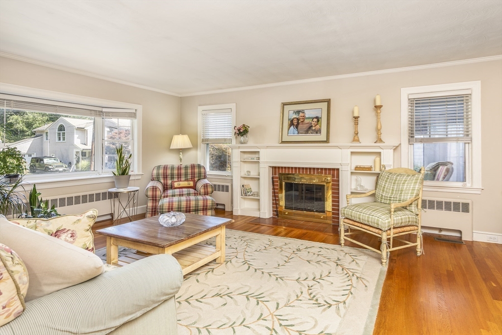 a living room with fireplace furniture and a large window