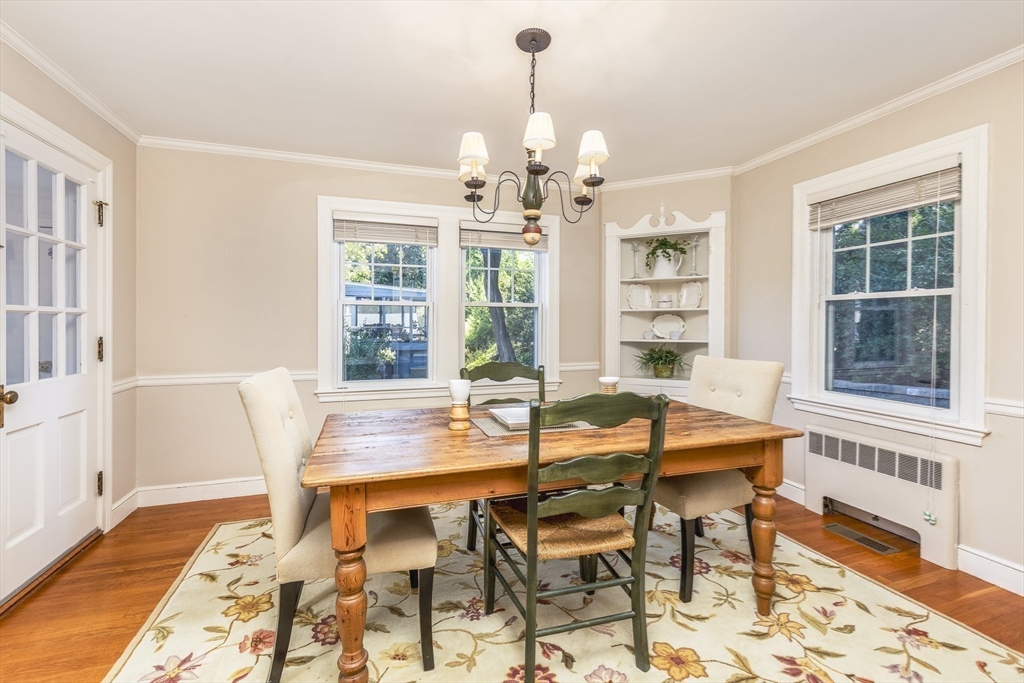 27 Preston Beach Road Marblehead, MA 01945 - Photo 7 of 32 a dining room with wooden floor a chandelier a wooden table and chairs