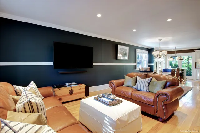a living room with furniture kitchen view and a flat screen tv