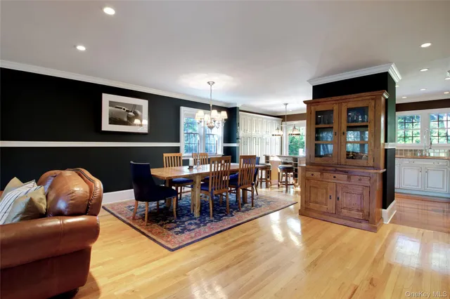 a living room with furniture a wooden floor and kitchen view