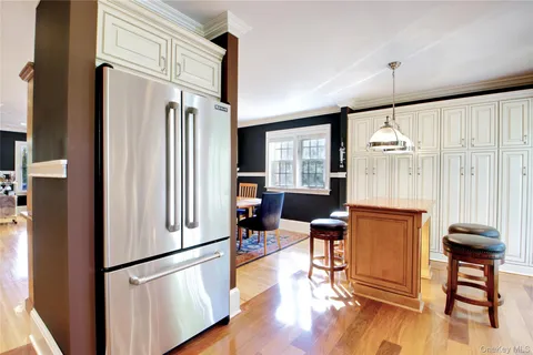 a kitchen with stainless steel appliances granite countertop a refrigerator and wooden floor