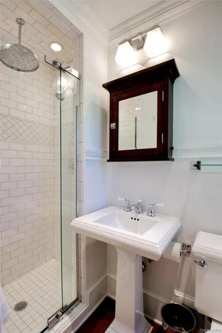 a bathroom with a sink mirror and a shower