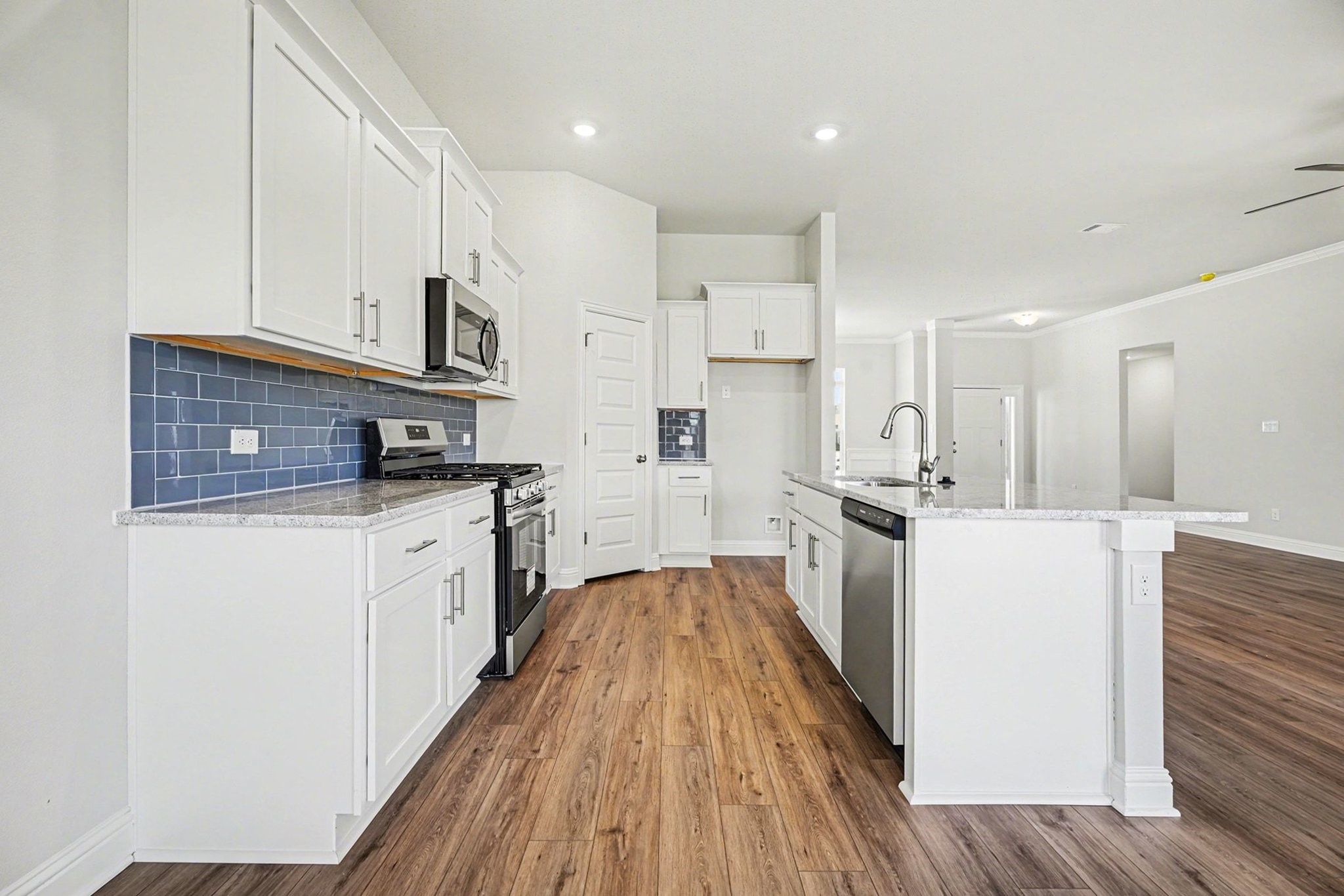 5 Keystone Court Angleton, TX 77515 - Photo 12 of 33 a kitchen with kitchen island white cabinets and stainless steel appliances