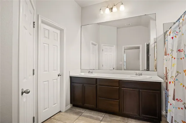 a bathroom with double sink and a mirror
