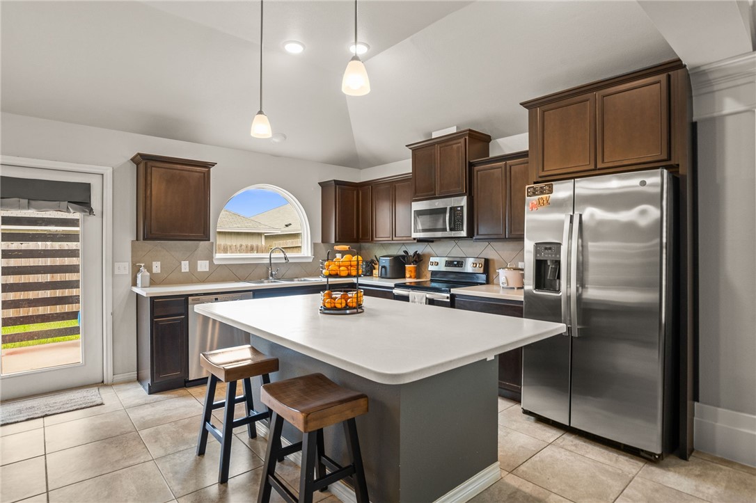 6718 Breeann Street Corpus Christi, TX 78413 - Photo 7 of 22 a kitchen with kitchen island a counter space a sink appliances and cabinets
