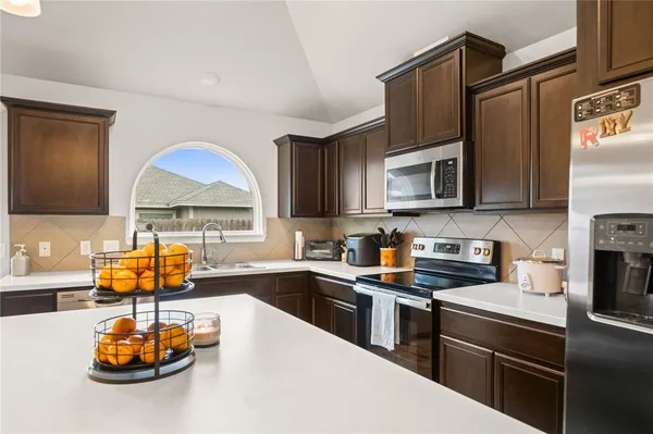 a kitchen with stainless steel appliances a stove a sink a microwave and refrigerator