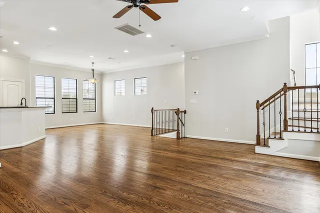 a view of an empty room with window and wooden floor