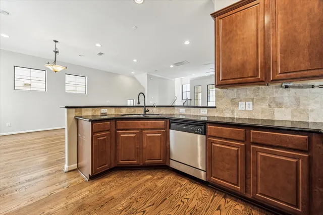 a kitchen with stainless steel appliances granite countertop wooden cabinets a sink and dishwasher