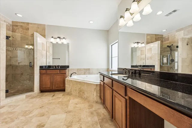 a large kitchen with a large counter top a sink stainless steel appliances and cabinets