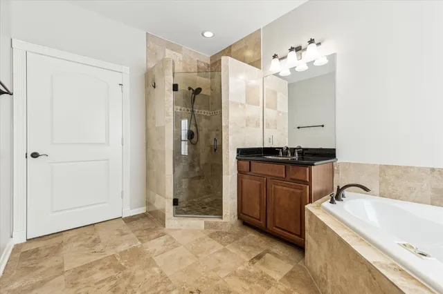 a bathroom with a granite countertop sink a mirror and a shower