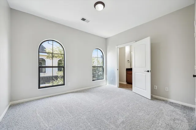 an empty room with windows and mirror