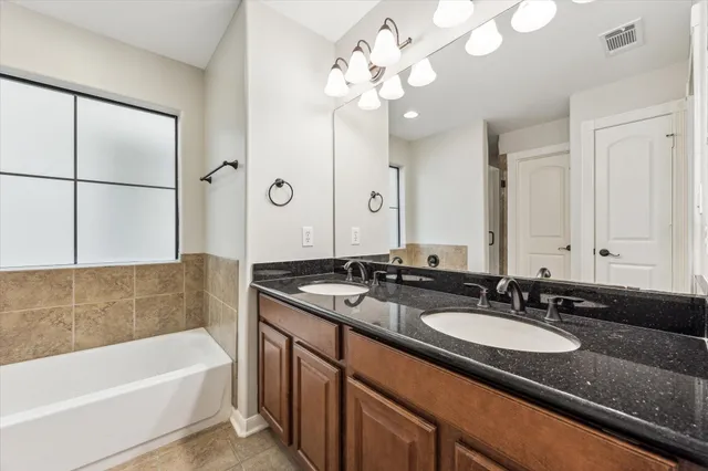 a bathroom with a granite countertop sink a large mirror and shower