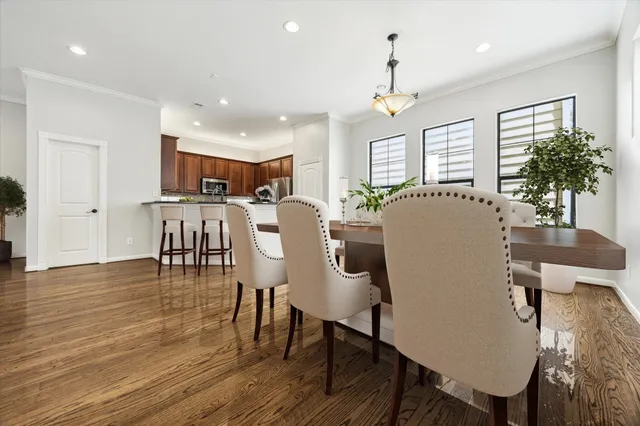 a dining room with furniture potted plants and wooden floor
