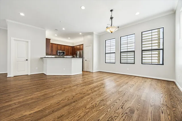 an empty room with wooden floor windows and ceiling fan
