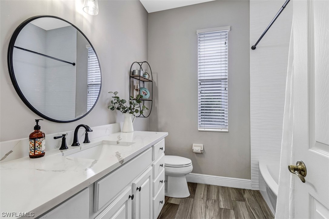 3944 Ruxton Road Naples, FL 34116 - Photo 11 of 23 a bathroom with a toilet a sink and a mirror