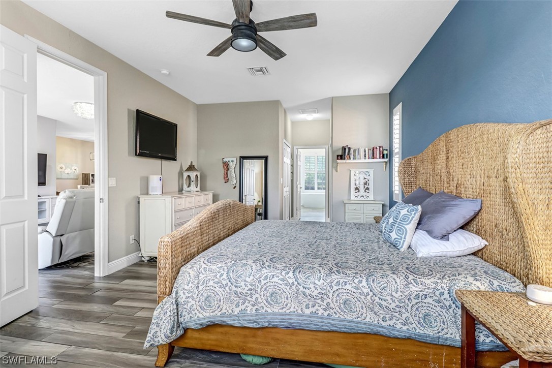 3944 Ruxton Road Naples, FL 34116 - Photo 15 of 23 a bedroom with a large bed a flat tv screen and a dresser