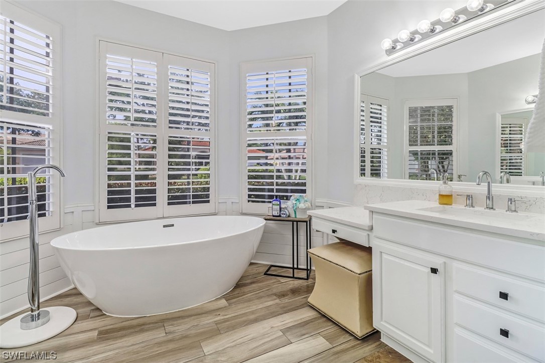 3944 Ruxton Road Naples, FL 34116 - Photo 17 of 23 a spacious bathroom with double vanity a window a bathtub and shower