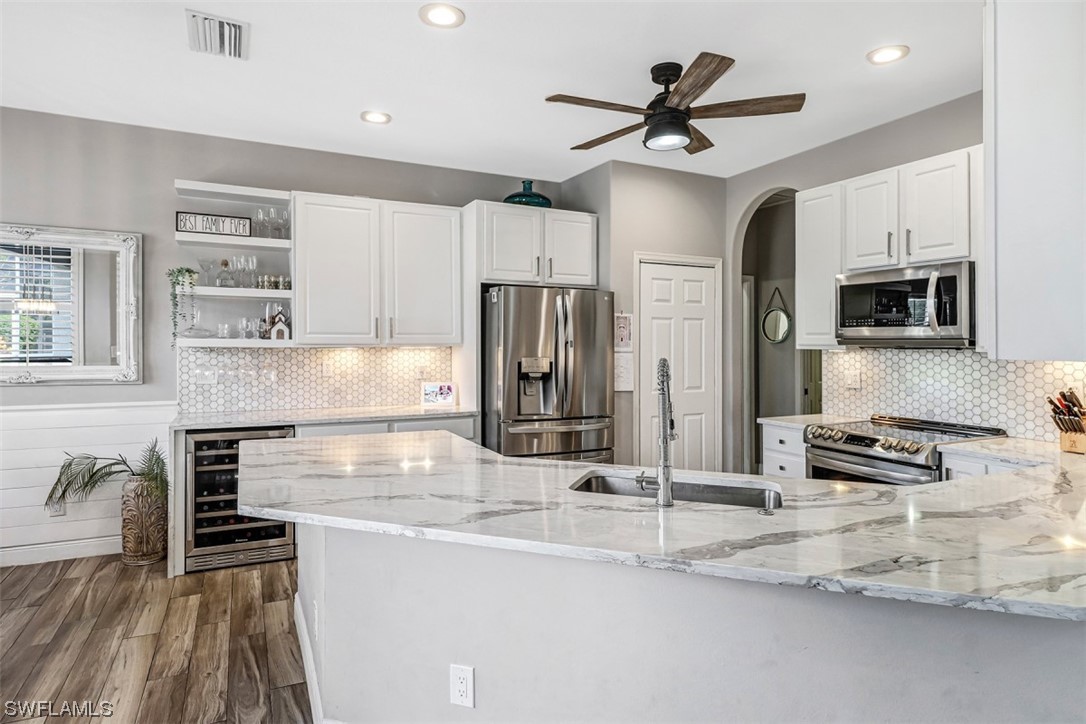 3944 Ruxton Road Naples, FL 34116 - Photo 4 of 23 a kitchen with stainless steel appliances granite countertop a sink stove and refrigerator