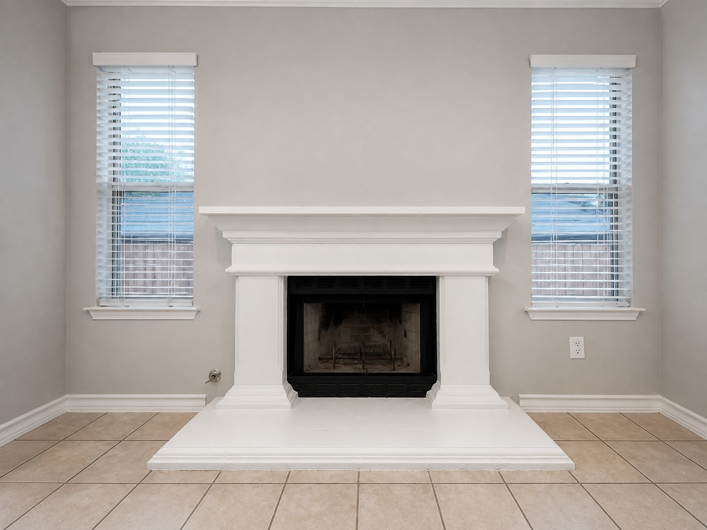14828 Single Trace Austin, TX 78728 - Photo 5 of 30 Fireplace with a white mantel and hearth, flanked by two windows with blinds