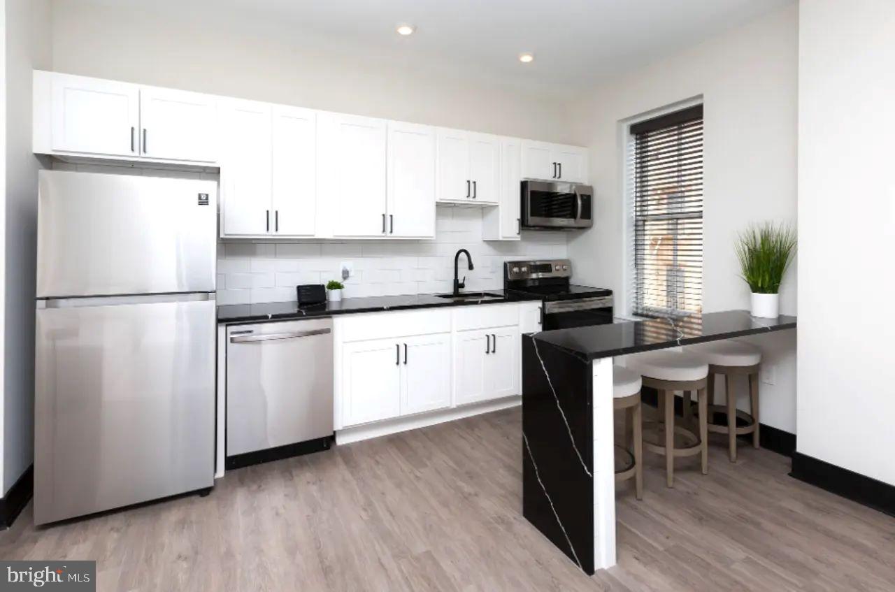a kitchen with white cabinets and white appliances