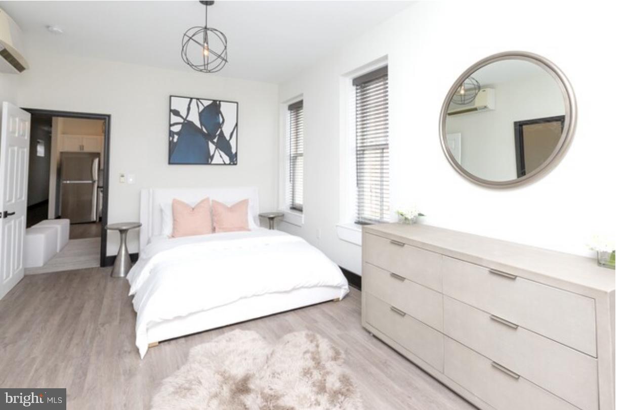938 North Calvert Street, Unit 1B Baltimore, MD 21202 - Photo 6 of 11 a bedroom with a large bed and a chandelier