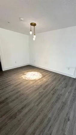 a view of a room with wooden floor