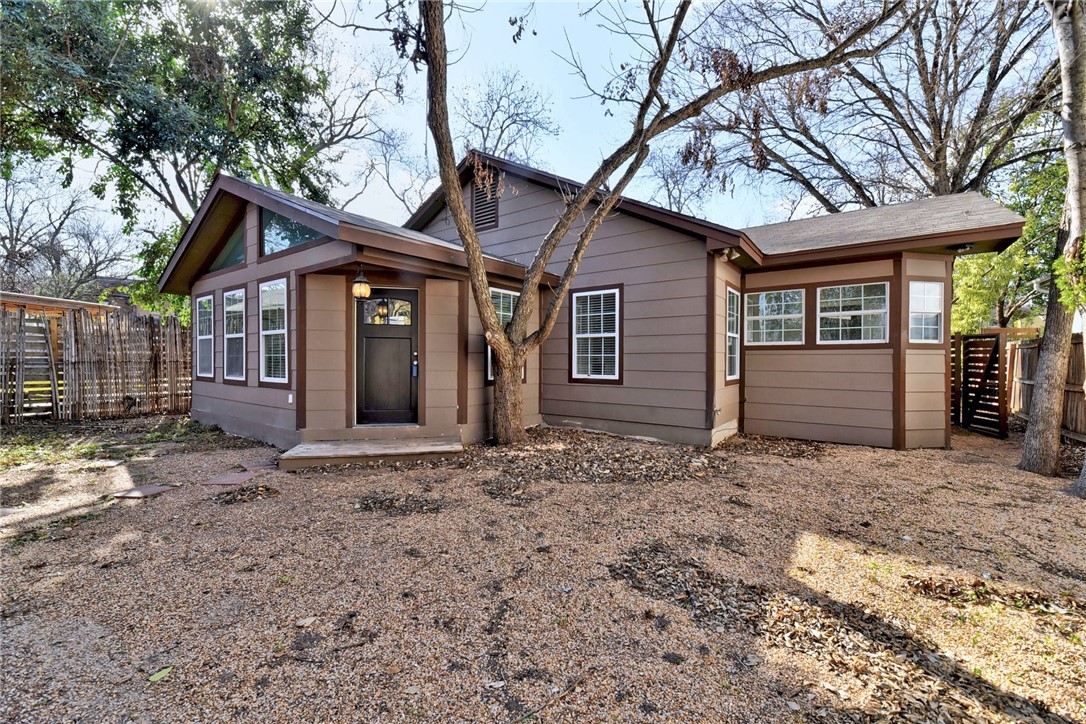 a backyard of a house with large trees and brick walls