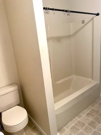 a white toilet sitting next to a bath tub