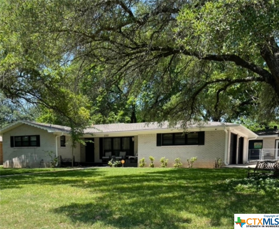 a front view of house with a garden and trees