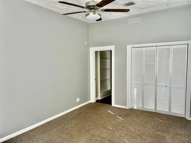 an empty room with a ceiling fan and a window